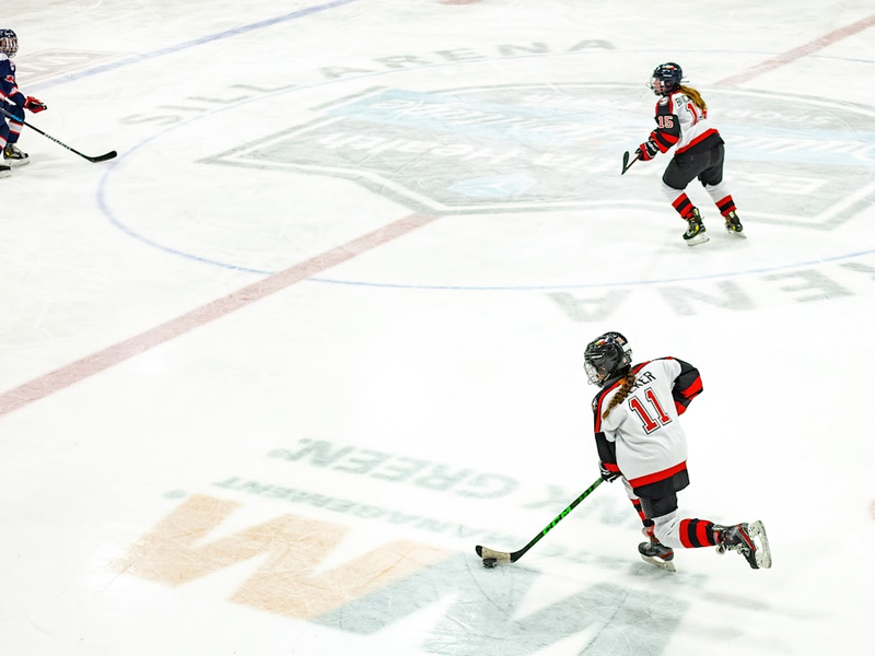 a group of people playing a game of ice hockey