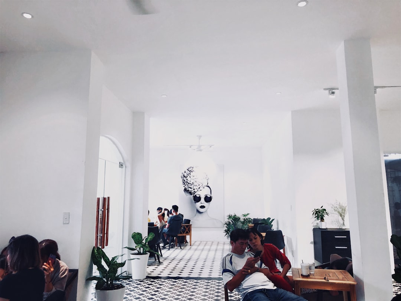 man and woman sitting on chair near white painted wall