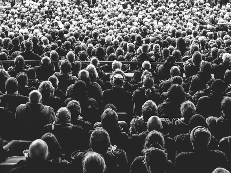 grayscale photo of people sitting on chair