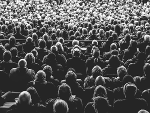 grayscale photo of people sitting on chair