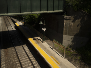 a train traveling down tracks next to a bridge