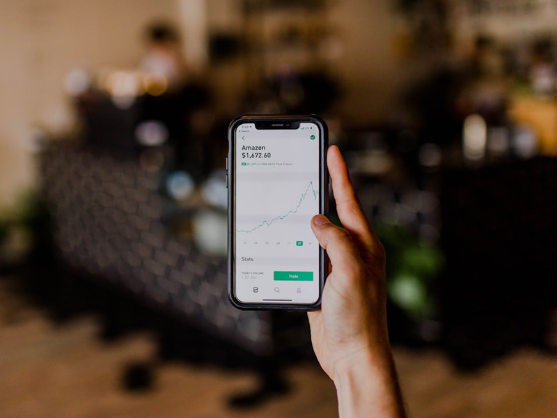 person holding black iPhone displaying stock exchange