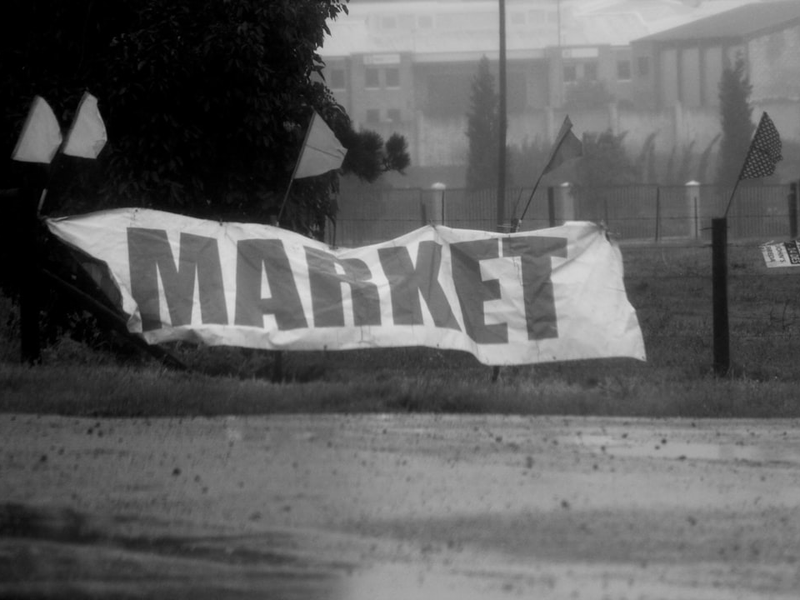 Just like the economy, a farmer's market sign holds on for dear life in the stormy weather.