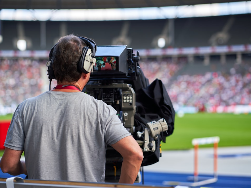 Cameraman at sports event capturing track and field athletes