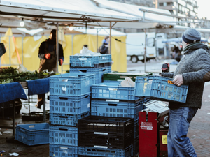 man carrying blue crates