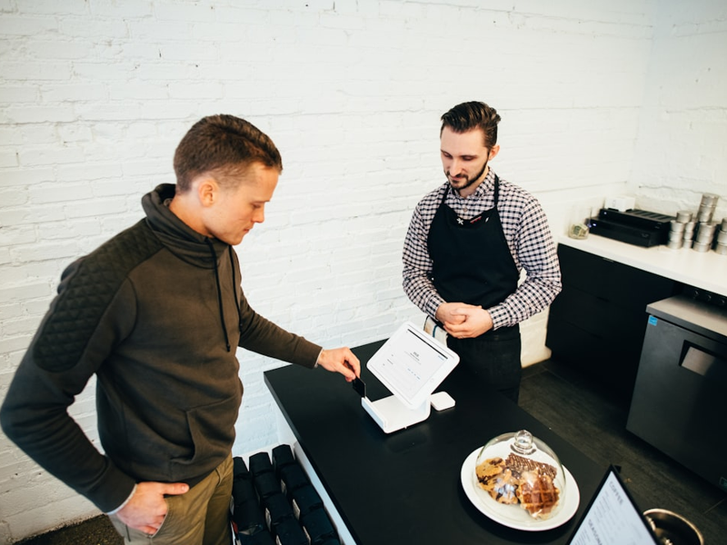 man looking at white digital device