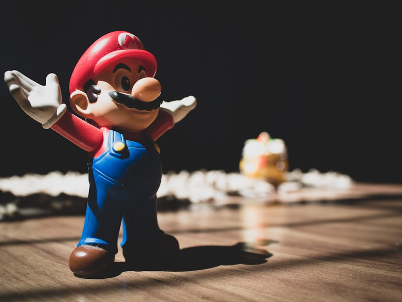 Super Mario figurine on brown surface