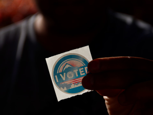 person holding white and blue round plastic container