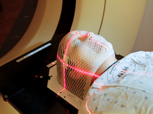 Lasers are used to position a patient model wearing a short face mask in a computed tomography (CT) scanner to obtain images of a tumor before radiation therapy. 2010