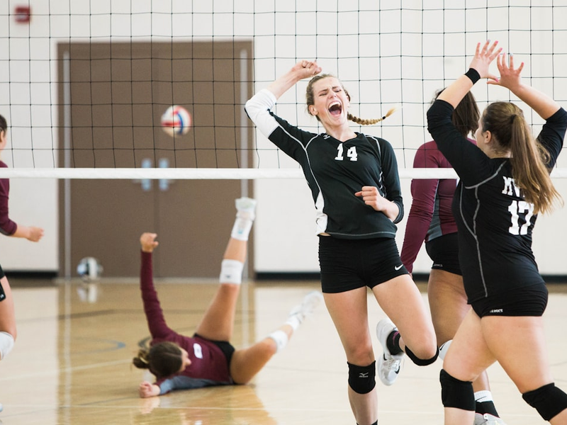 women playing volleyball inside court