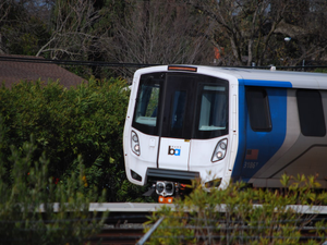 a white and blue train traveling down train tracks