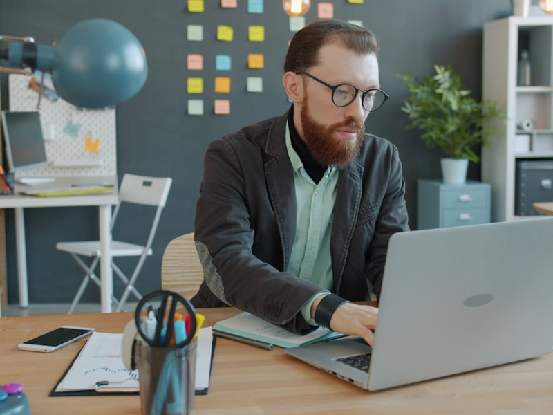 Unhappy young man is working with laptop then feeling mad about failure and leaving. Workplace, modern technology and negative emotions concept.