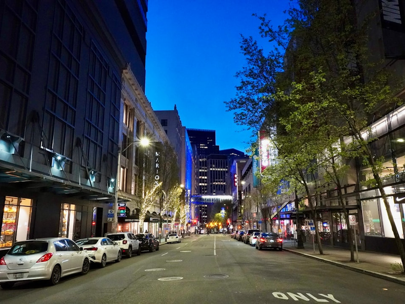 Seattle street in Westlake at night showing Nordstrom and popular retail stores.