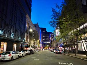 Seattle street in Westlake at night showing Nordstrom and popular retail stores.