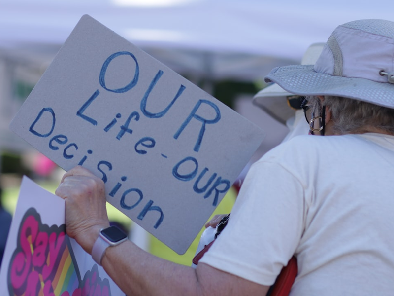 a man holding a sign that says our life - our decision