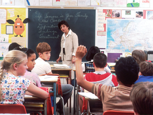 Children in a Classroom. In the back of a classroom, are children about 11 years old with a female teacher talking about the subject - If Someone in Your Family Has Cancer. Photographer Michael Anderson