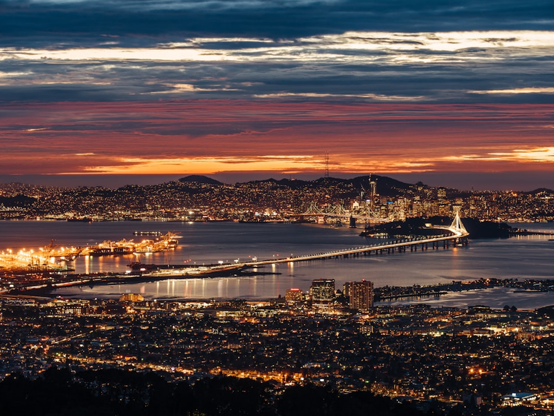 aerial view of lighted city buildings near river during golden hour