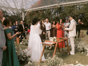 A wedding ceremony is taking place outdoors.