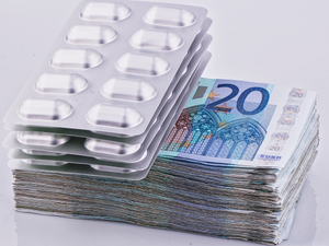 a stack of 20 euro bills next to a pack of 20 pills