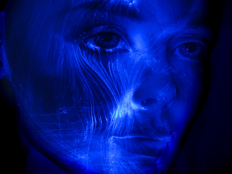 Futuristic light painting of a woman portrait, veins of fibre optic light passing through her face.