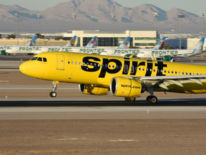 Spirit Airlines A320neo landing in Las Vegas with Frontier Airlines jets in the background