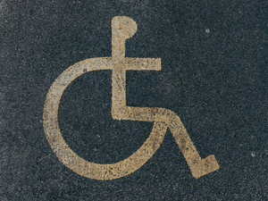 Disabled parking. Accessible parking spot. Blue badge. Yellow wheelchair sign on the ground