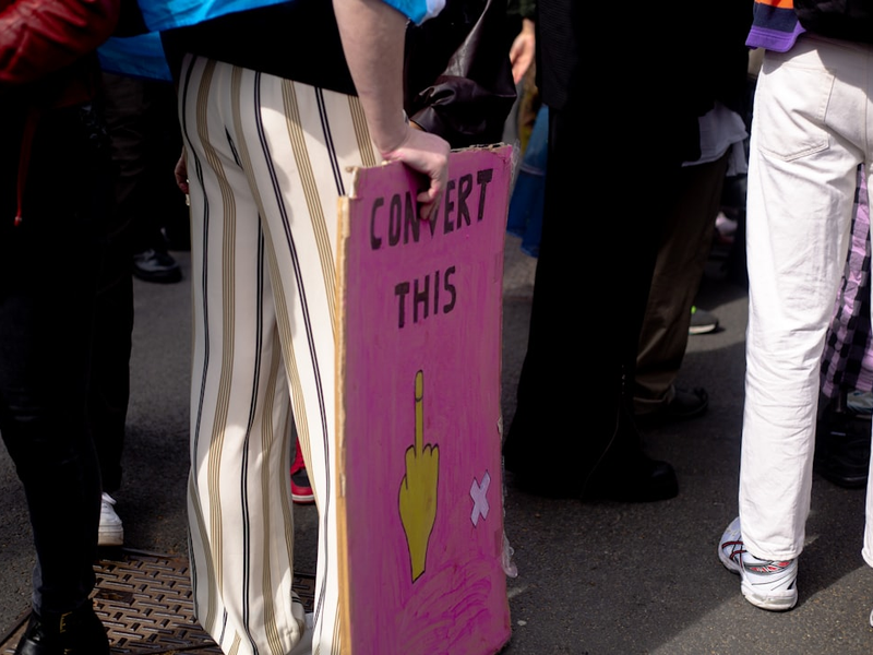 a group of people standing around a pink sign