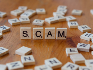 Scam spelled with scrabbles on a wooden table