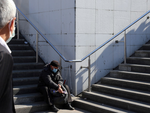 man in black jacket sitting on stairs