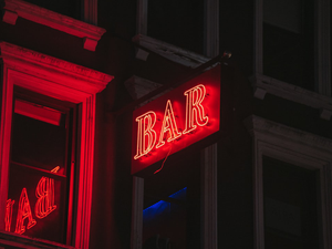 a red bar sign lit up in the dark