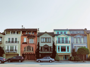gray sedan parked near multicolored building during daytime