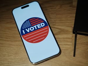 A cell phone with a vote sticker on it