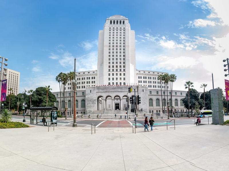 people walking on park near white concrete building during daytime