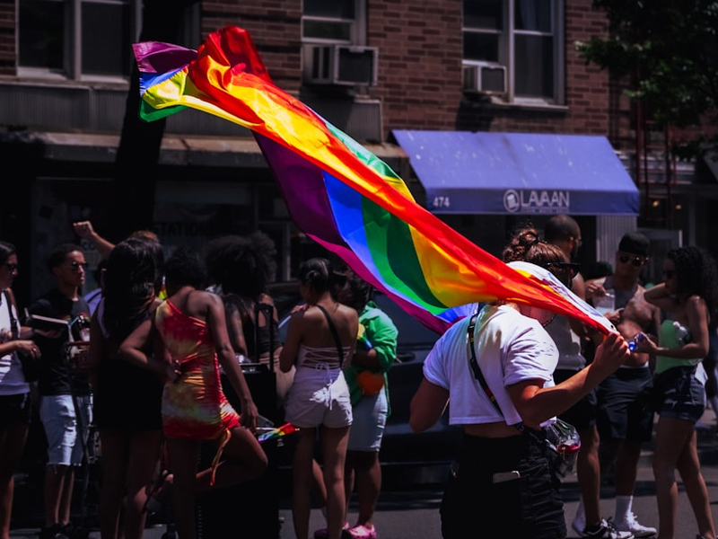 a person holding a rainbow flag