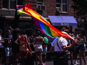 a person holding a rainbow flag