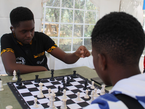 a young man playing chess with another young man