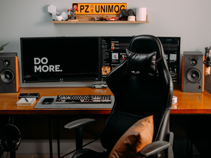 a person sitting at a desk with a computer and speakers