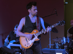 A man standing on a stage playing a guitar