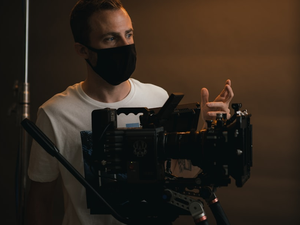 a man wearing a face mask while holding a camera
