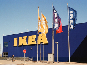 The ikea store with flags and blue exterior.