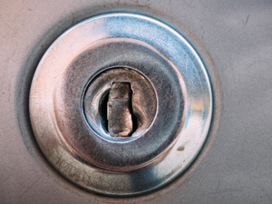 Close-up picture of a damaged car door lock after attempted lock picking and motor vehicle theft