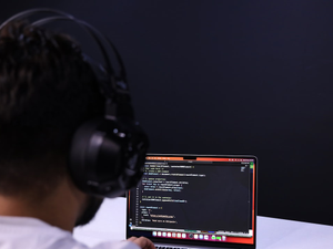 a man wearing headphones and using a laptop