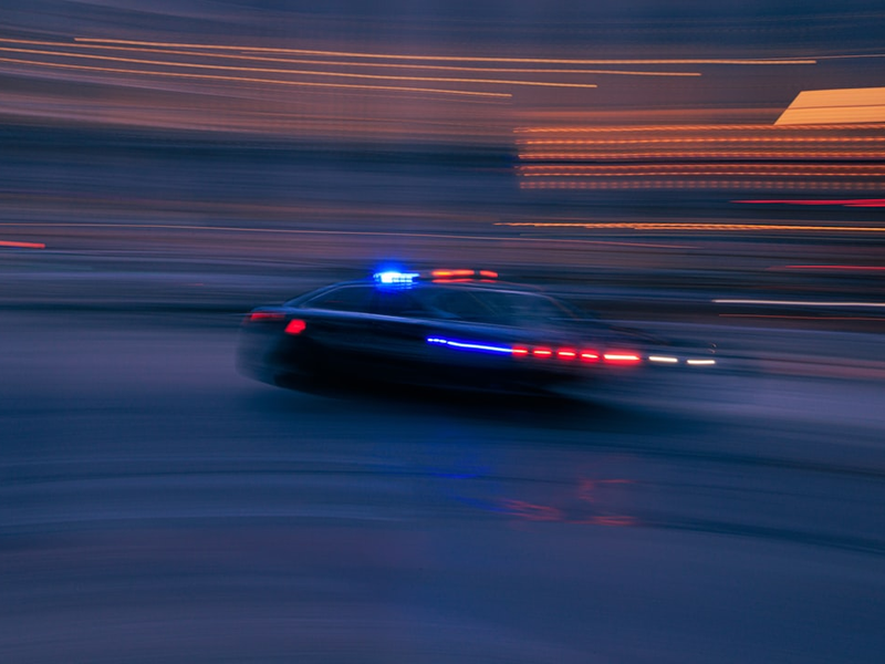 Fast moving police car down a city street.