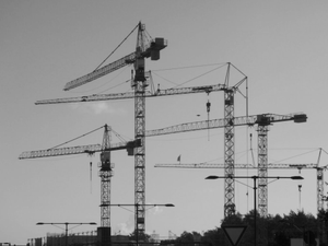 a black and white photo of construction cranes