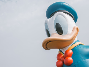 a large mickey mouse balloon with a bow tie