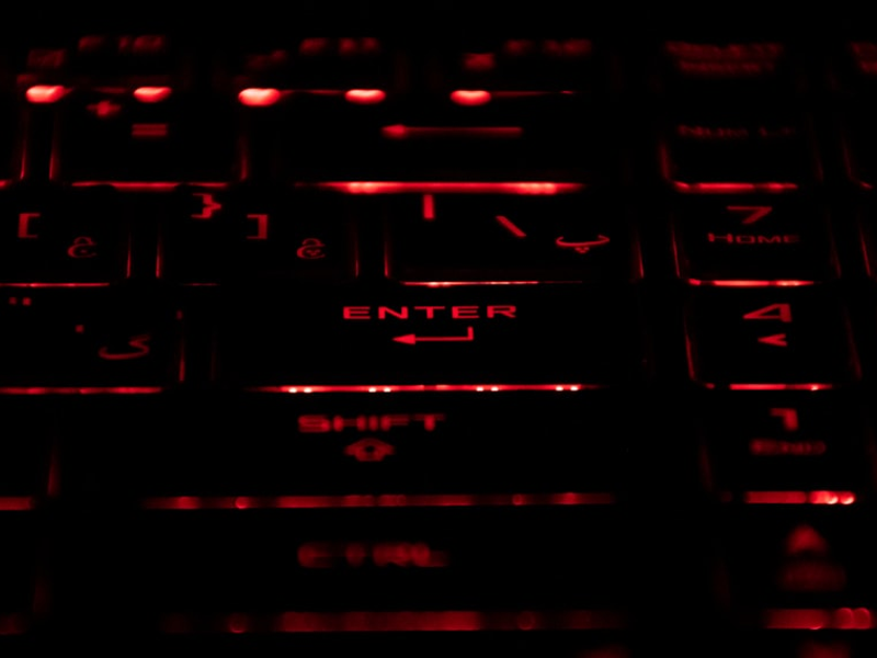 a close up of a computer keyboard with red light