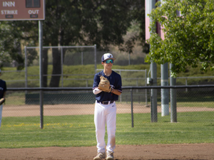 Baseball players stand on the field during a game.