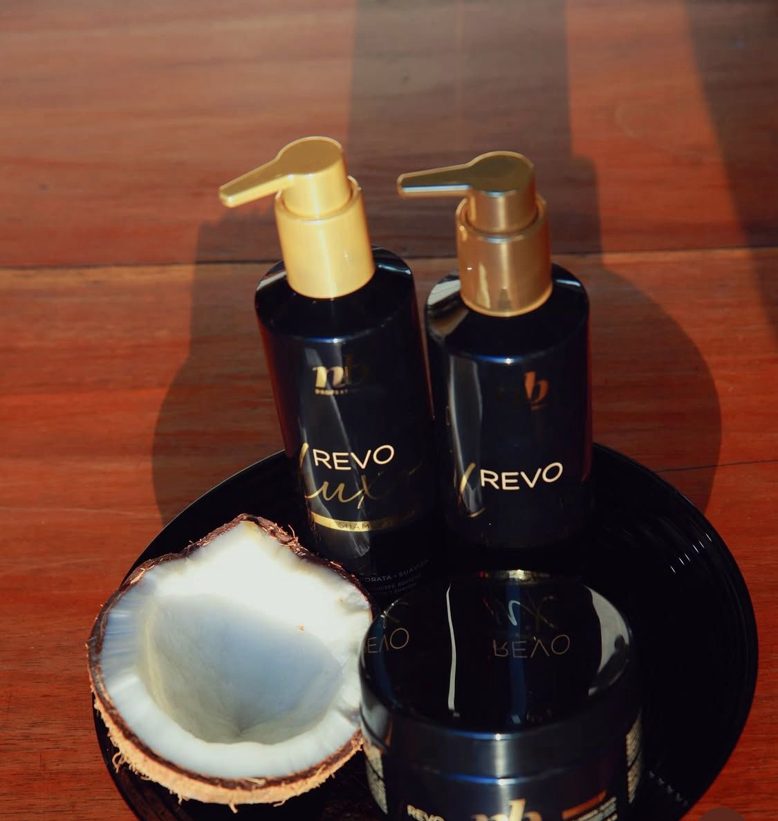 Botellas de productos de la línea Revo Lux de NB Professional sobre una superficie limpia.