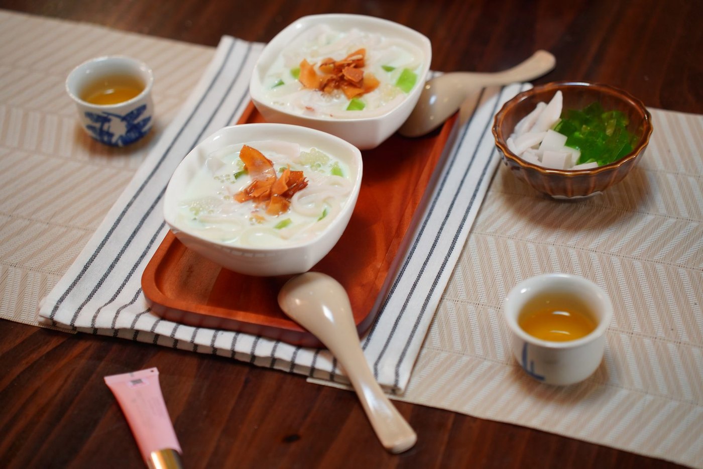 Two bowls of rice porridge with tea, lit and styled for a Samsung Z Flip7 film