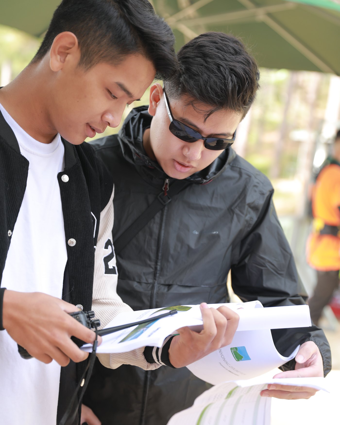 Two producers with a radio reading the day's schedule on a location shoot in Da Lat